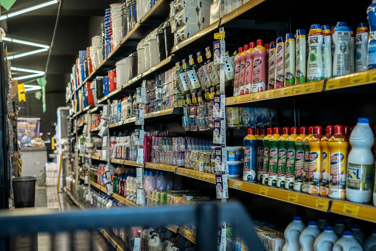 Corredor da loja Nacional Limp com produtos de limpeza abastecidos
